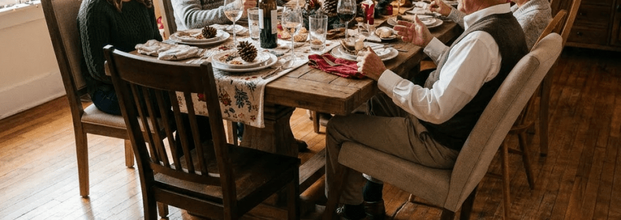 Dining table with Christmas decorations, wine bottles, glasses, and place settings