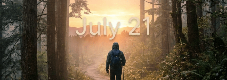 Person hiking on foggy forest path with walking stick and backpack